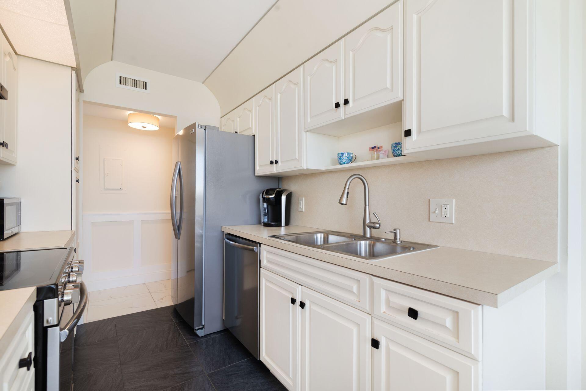 1701 South Flagler Drive, Unit 207 West Palm Beach, FL 33401 - Photo 10 of 26 a kitchen with stainless steel appliances granite countertop a sink stove and refrigerator