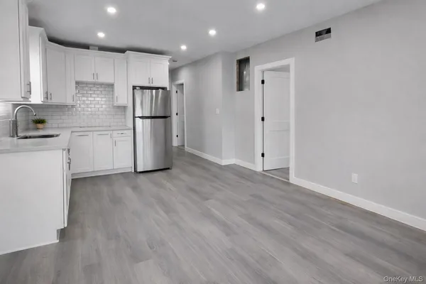 a kitchen with a refrigerator sink and cabinets
