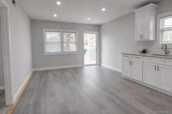 a view of a kitchen with wooden floor and a window