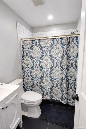 a bathroom with a toilet and a shower curtain