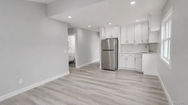 a view of kitchen with refrigerator cabinets and wooden floor