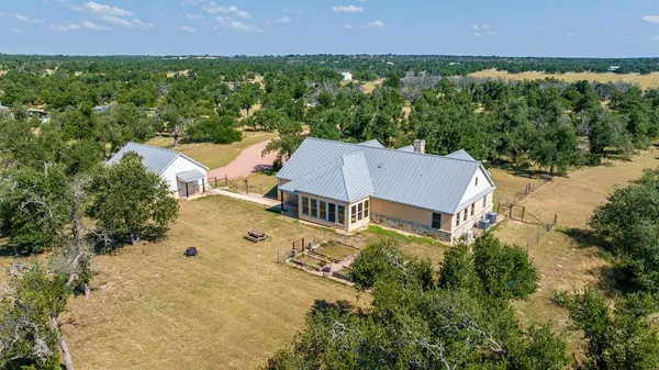 an aerial view of a house with a yard and lake view