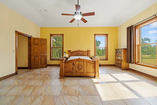 a spacious bedroom with a balcony a bed and a large window