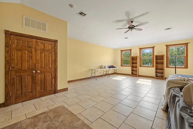 a spacious bedroom with a bed and a chandelier