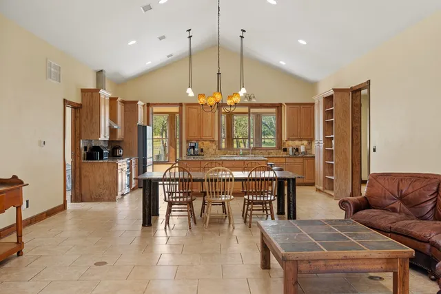 a dining table seating space a large window and kitchen view