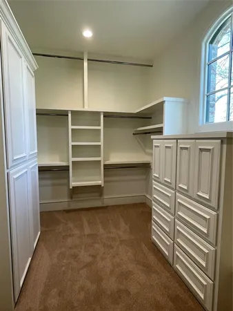 a view of walk in closet with empty racks
