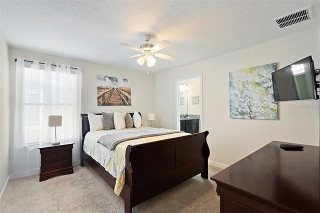 a bedroom with a large bed and a ceiling fan