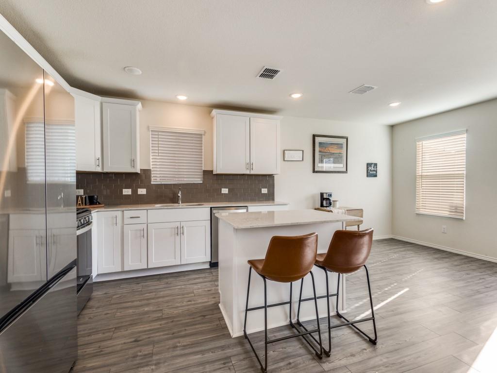 16033 Pemberly Lane Haslet, TX 76052 - Photo 12 of 27 a kitchen with stainless steel appliances granite countertop a stove a sink a refrigerator with white cabinets and wooden floor