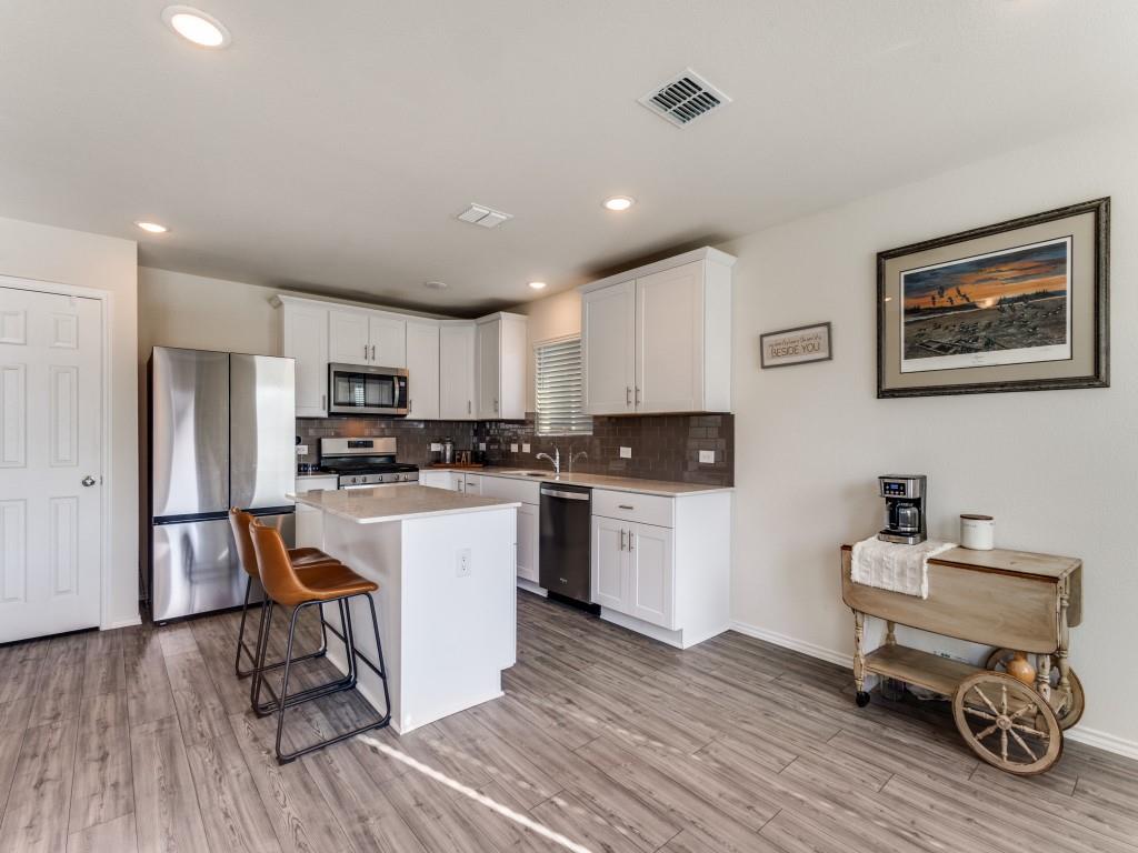 16033 Pemberly Lane Haslet, TX 76052 - Photo 13 of 27 a kitchen with a refrigerator and white cabinets