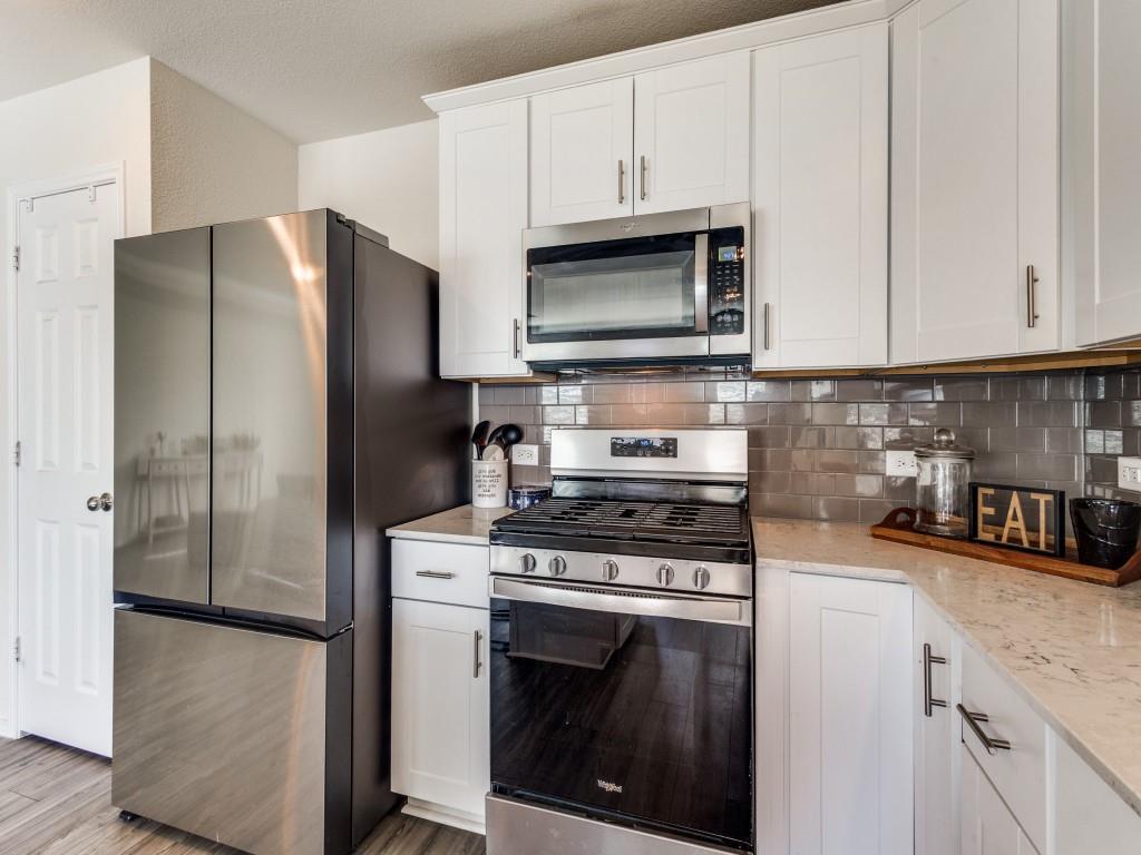 16033 Pemberly Lane Haslet, TX 76052 - Photo 14 of 27 a kitchen with stainless steel appliances white cabinets white stove a refrigerator and a microwave