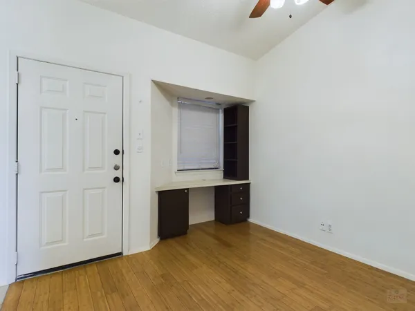 a view of empty room with wooden floor