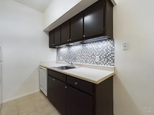 a kitchen with a sink cabinets and wooden floor