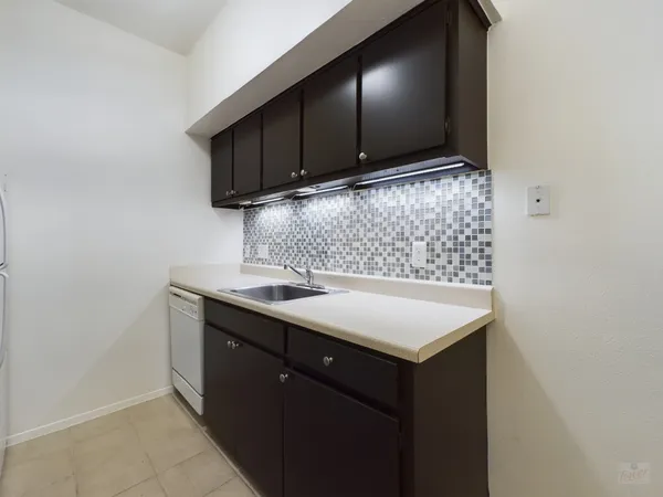 a kitchen with a sink cabinets and wooden floor