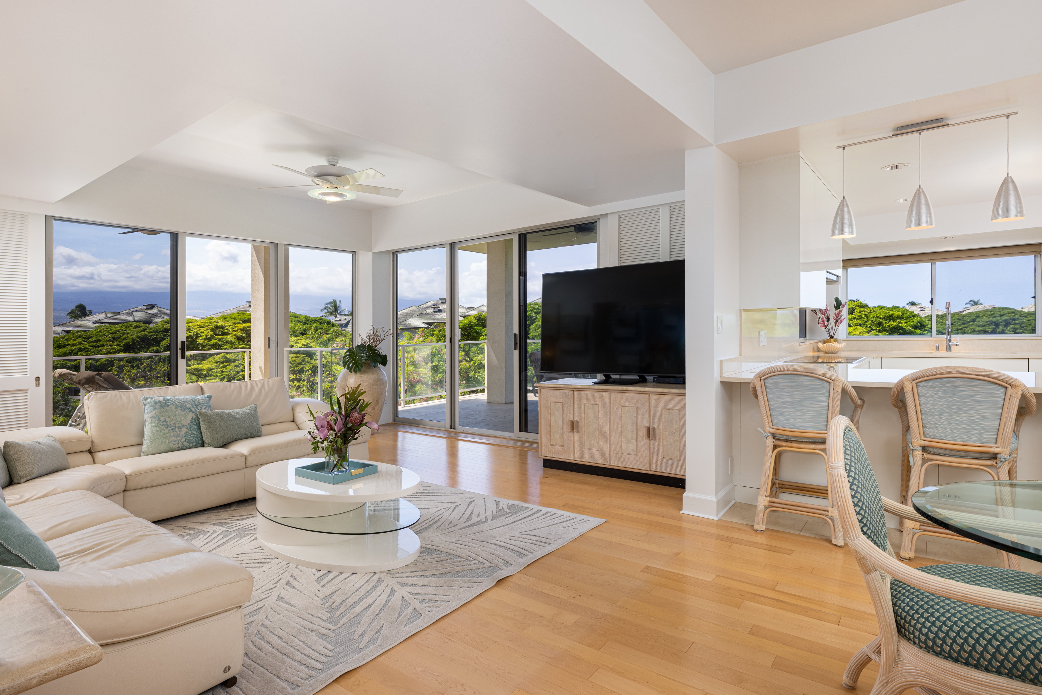 a living room with furniture a flat screen tv and a floor to ceiling window