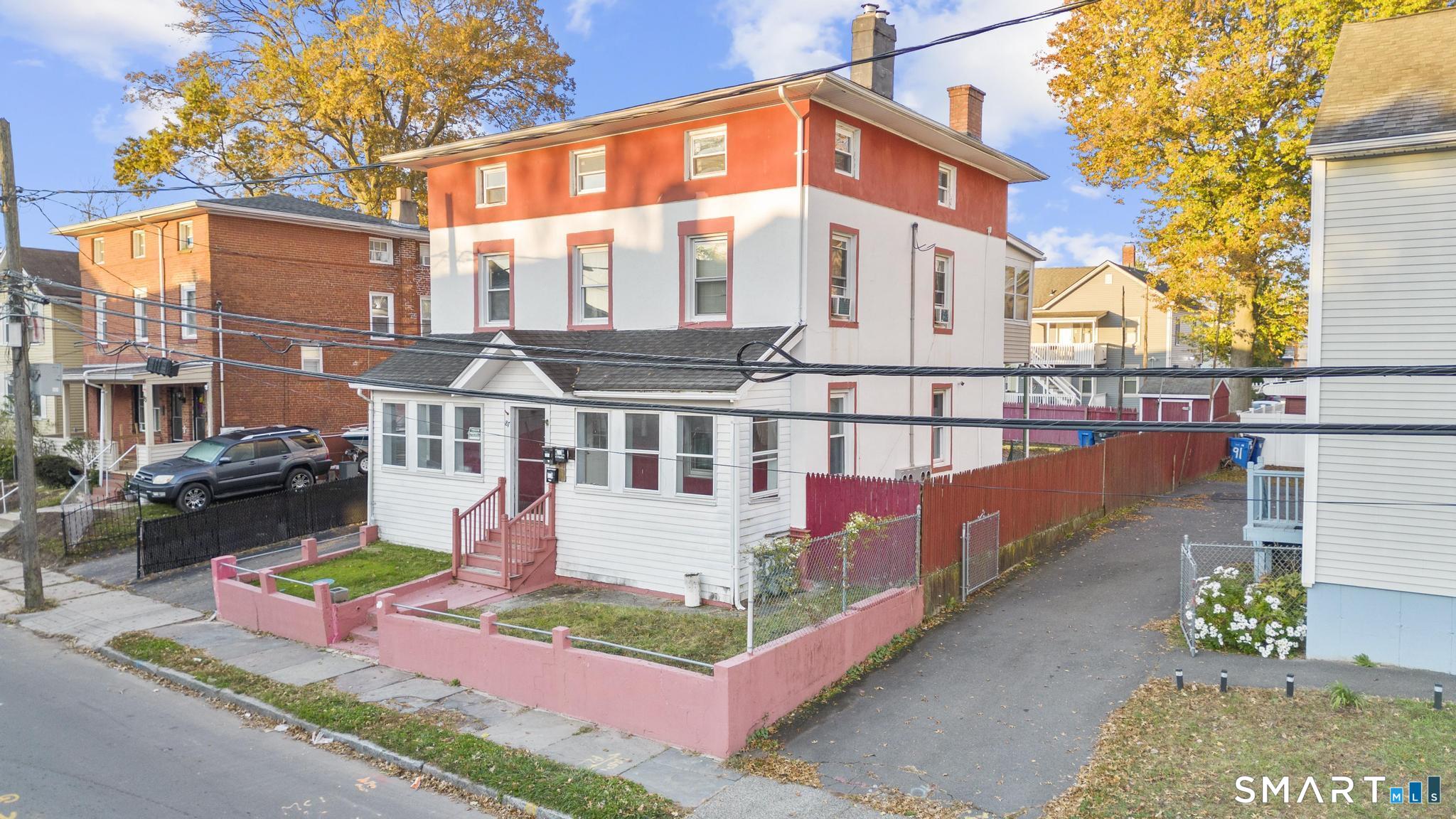 87 Amity Street Hartford, CT 06106 - Photo 2 of 38 a view of a blue and white house with large windows and a small yard