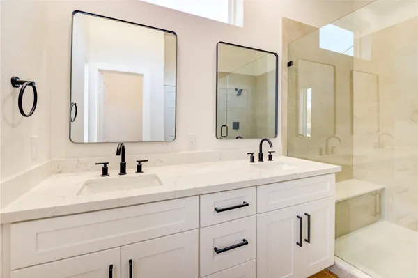 a bathroom with a double vanity sink mirror and