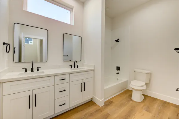 a bathroom with double vanity sinks and a mirror