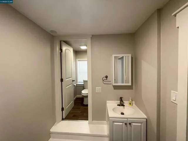 a view of a kitchen with a sink refrigerator and wooden floor