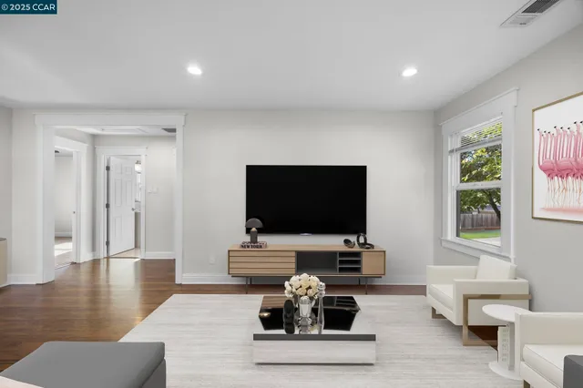 a living room with furniture kitchen view and a window