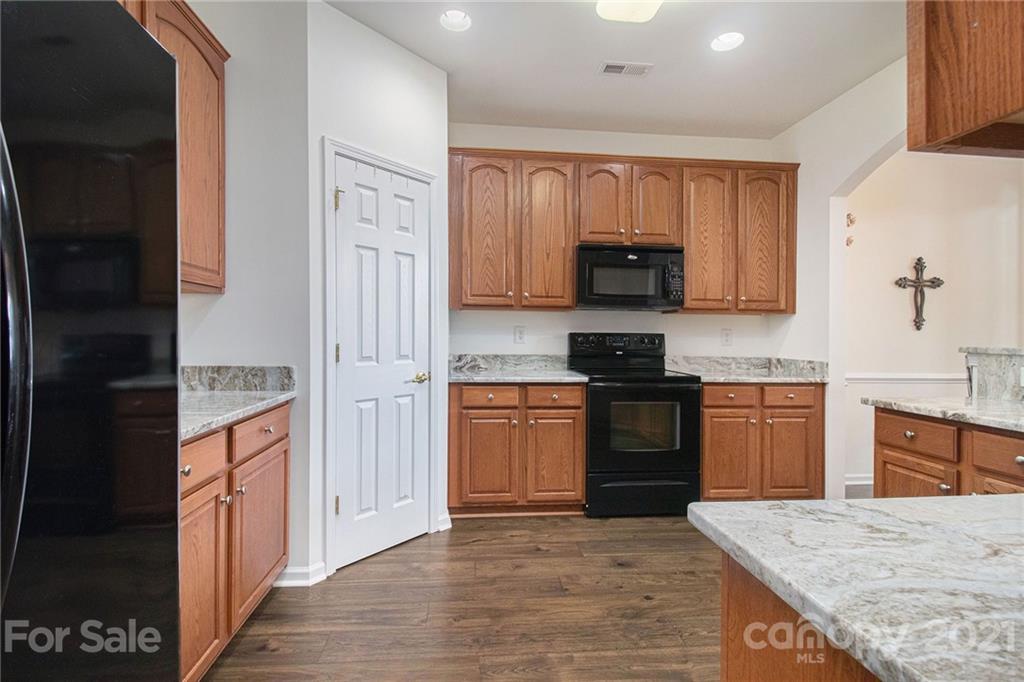 287 Garnet Court Fort Mill, SC 29708 - Photo 3 of 30 a kitchen with granite countertop a refrigerator stove top oven and sink
