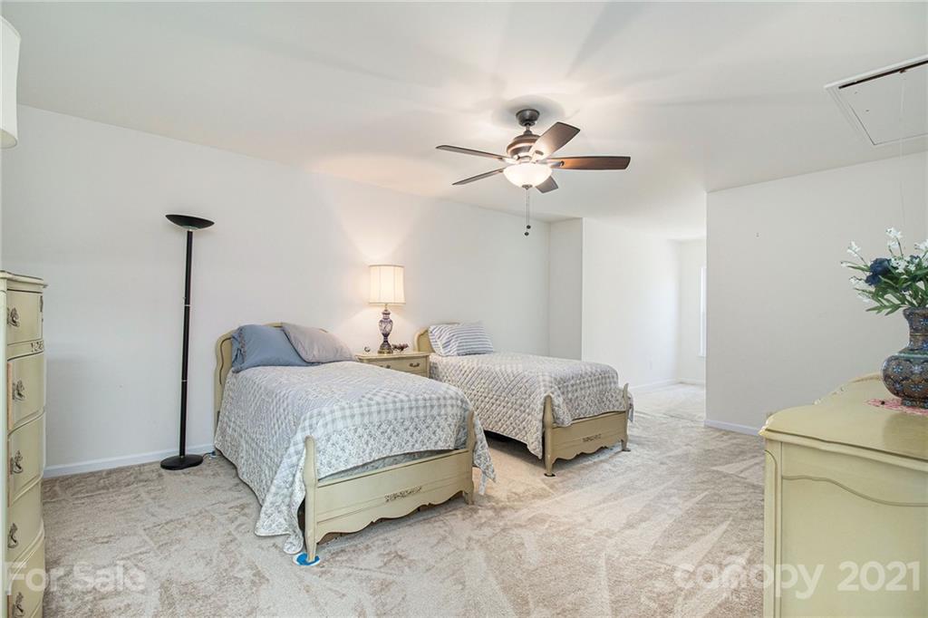 287 Garnet Court Fort Mill, SC 29708 - Photo 22 of 30 a spacious bedroom with a bed and a chandelier