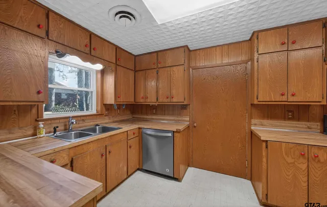 a kitchen with stainless steel appliances a sink a stove and cabinets