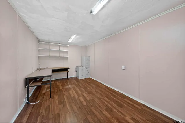 an empty room with windows and ceiling fan