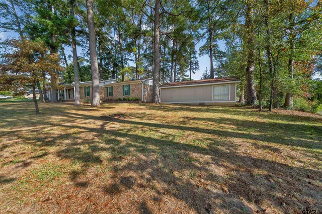 a view of a house with a yard and tree s