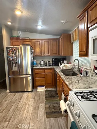 a kitchen with a stove a sink a microwave a window and cabinets