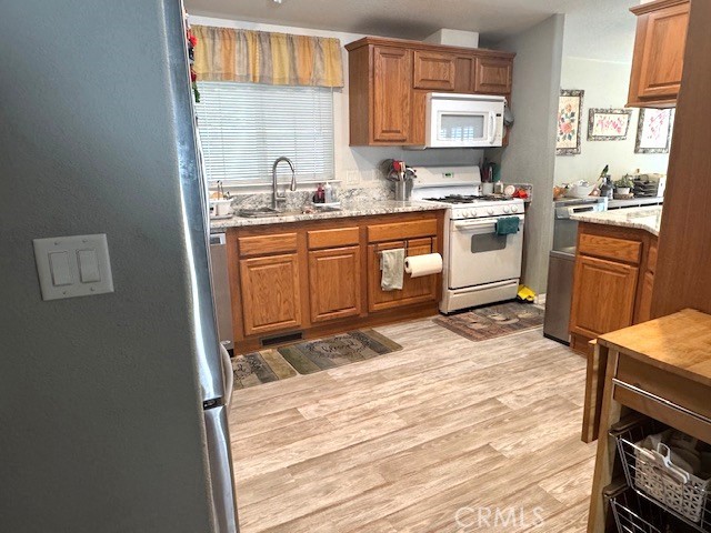 7271 Katella Avenue, Unit 99 Stanton, CA 90680 - Photo 7 of 15 a kitchen with a stove a sink a microwave a window and cabinets