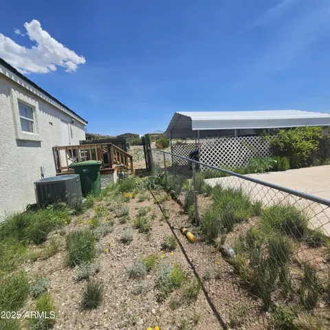 a view of a dry yard with wooden fence