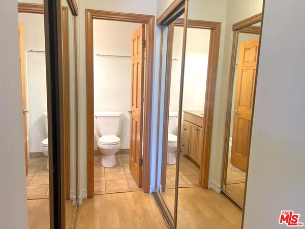 a bathroom with a granite countertop toilet sink mirror and vanity