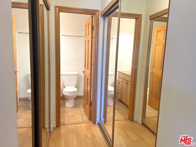 a bathroom with a granite countertop toilet sink mirror and vanity