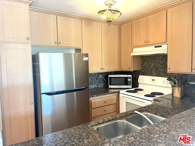 a kitchen with a refrigerator a stove a sink and a window