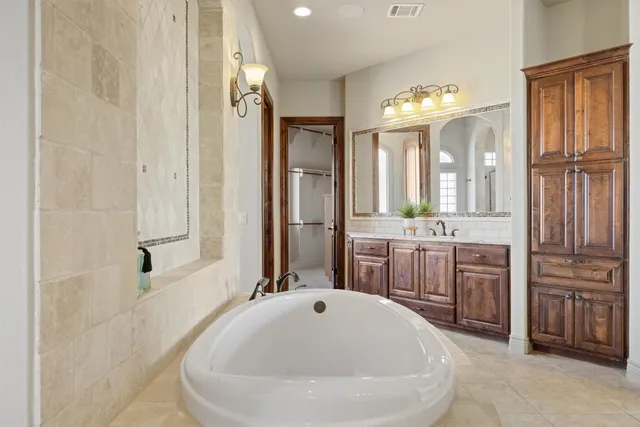 a bathroom with a tub sink and mirror