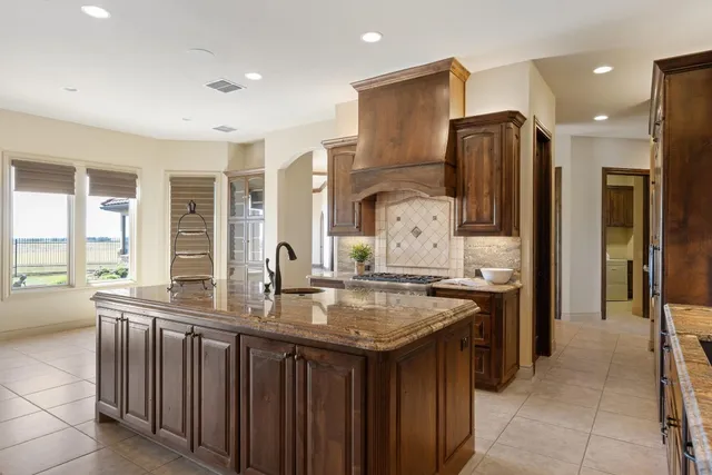 a kitchen with stainless steel appliances granite countertop a refrigerator a sink and a stove