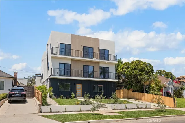 a front view of a building with a garden and plants