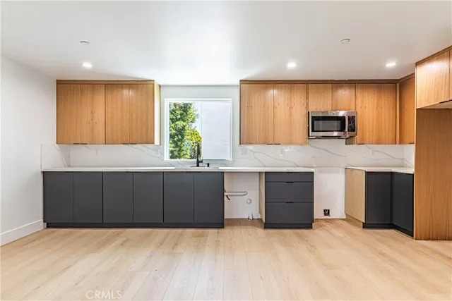a kitchen with granite countertop a stove a sink and a microwave