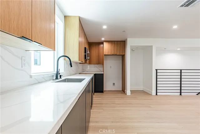 a kitchen with stainless steel appliances a sink and a refrigerator