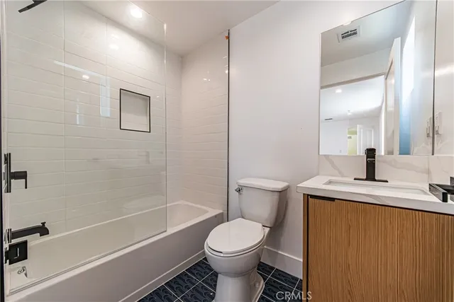 a bathroom with a granite countertop toilet sink and mirror