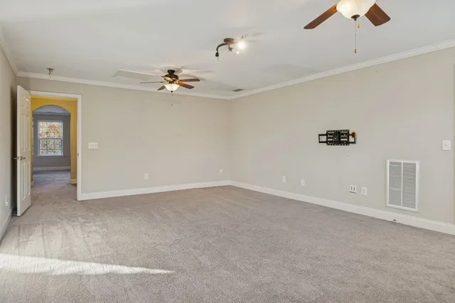 an empty room with windows and fan