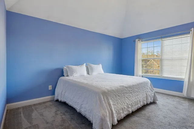 a bed sitting in a bedroom next to a window