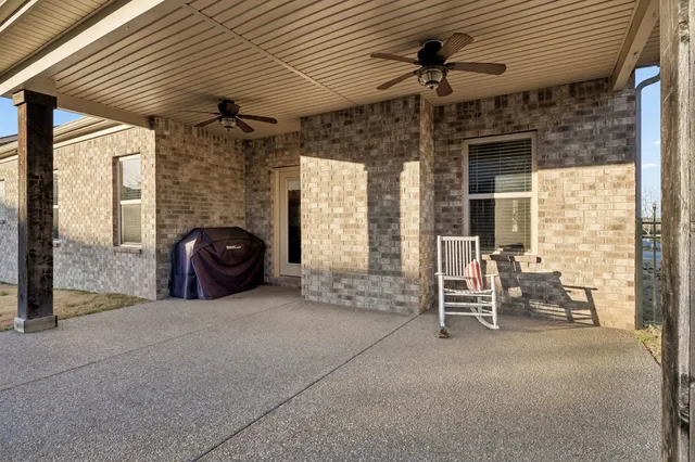 a view of a patio with table and chairs and a barbeque