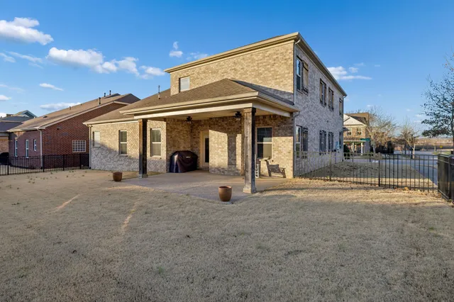 a view of a house with backyard and a parking