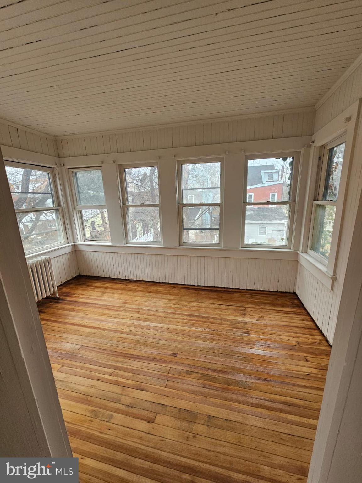 263 Highland Avenue Trenton, NJ 08618 - Photo 7 of 8 a view of an empty room with wooden floor and a window