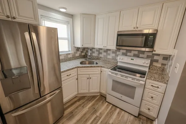 a kitchen with white cabinets and stainless steel appliances