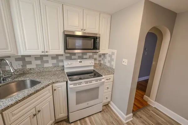 a kitchen with white cabinets stainless steel appliances and sink