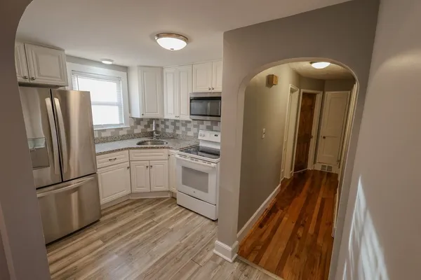 a kitchen with white cabinets and stainless steel appliances