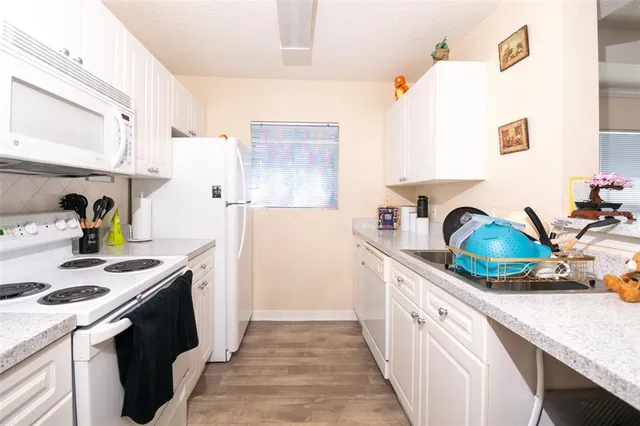 a kitchen with a sink a stove and cabinets