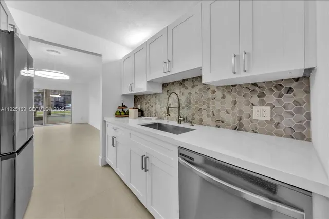 a kitchen with stainless steel appliances granite countertop a sink and dishwasher a stove top oven with wooden floor